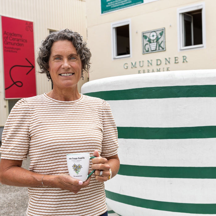 Kristina von Trapp outside the Gmundner Keramik manufactory holding an Edelweiss cup