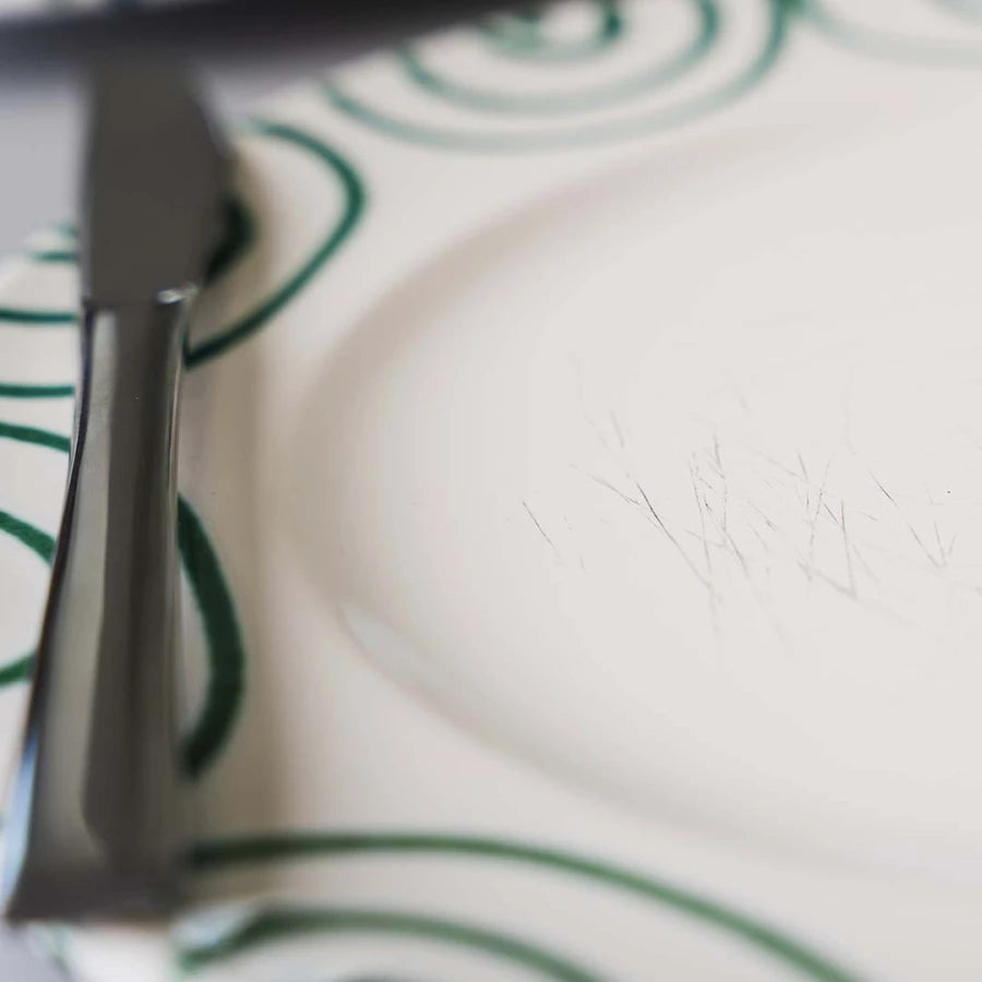 Close-up of cutlery marks on a green-flamed ceramic plate