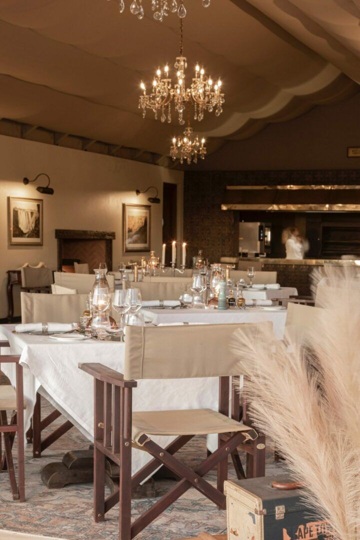 Gmundner Lodge. Dining area with wooden chairs, a chandelier, and framed pictures on the wall.