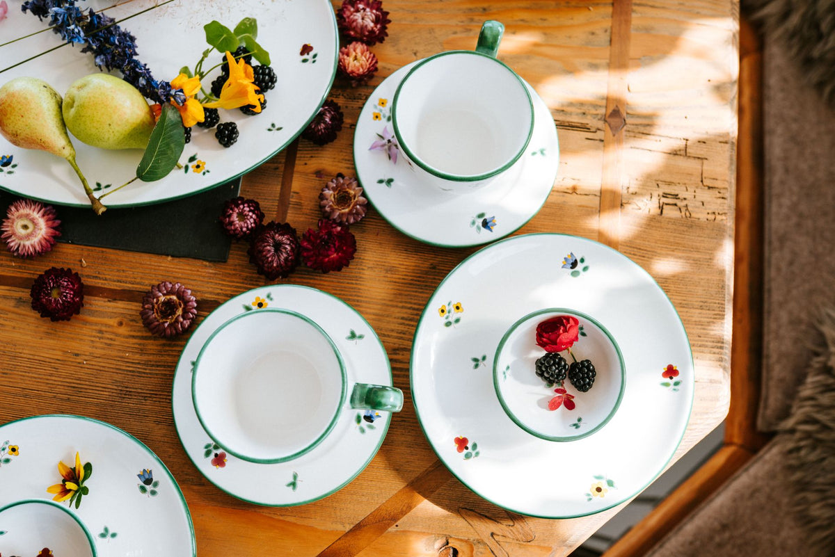 Alpine Flowers tableware with pears and berries on a wooden table