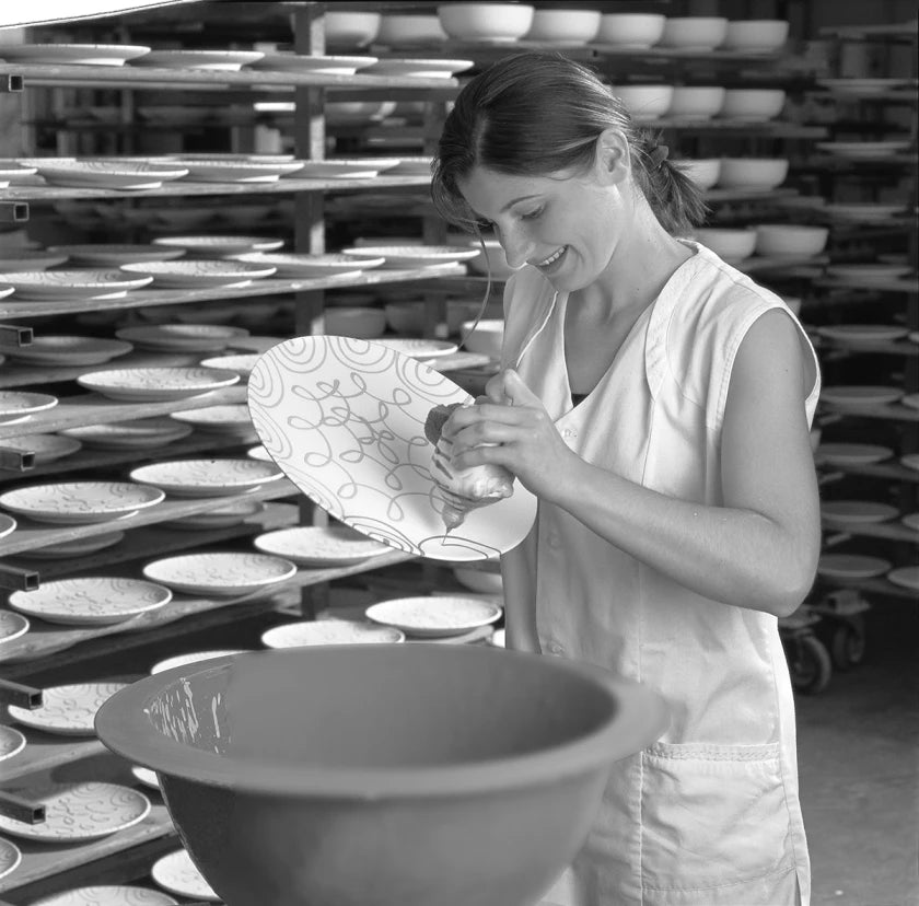 Archive photograph of a maker decorating a ceramic plate